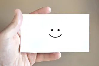 Ein Kärtchen in der Hand mit einem Smiley